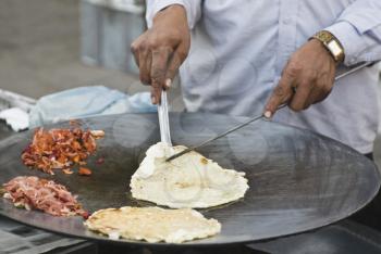 Man preparing egg roll in a stall, New Delhi, India