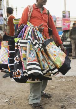 Vendor selling bags in a street market, New Delhi, India