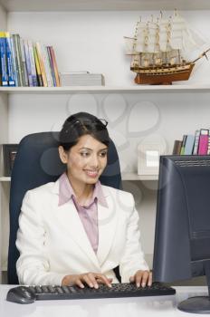 Businesswoman working on a desktop PC in an office