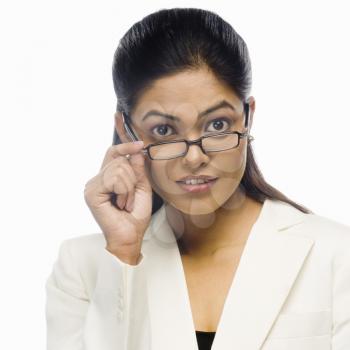 Portrait of a curious businesswoman holding her eyeglasses