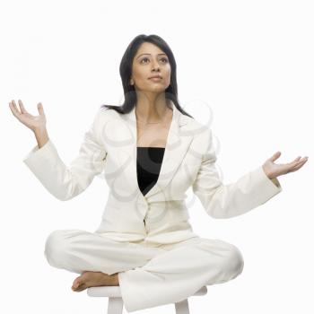 Businesswoman meditating on a stool