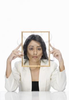Businesswoman looking through a picture frame