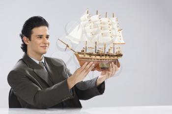 Businessman looking at a model ship