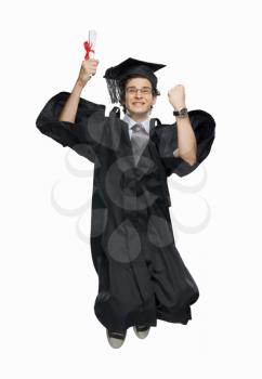 Happy male graduate holding his diploma and jumping