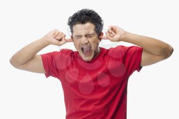 Man screaming with his fingers in ears