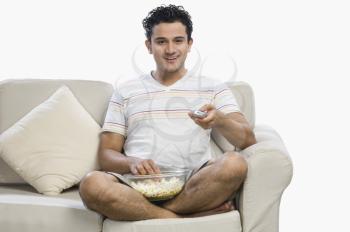 Man watching television with popcorns