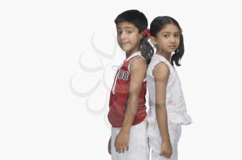 Portrait of two children standing back to back