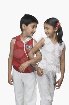 Two children looking at each other with their arm in arm