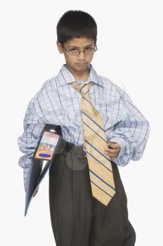 Portrait of a boy wearing oversized clothes and holding a file
