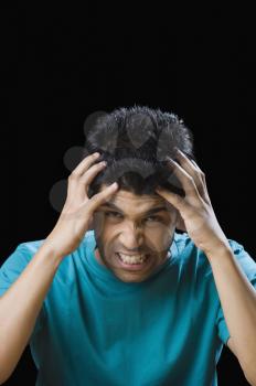 Close-up of a frustrated man holding his head