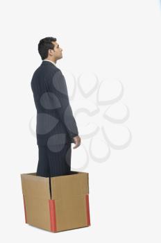 Businessman standing in a cardboard box