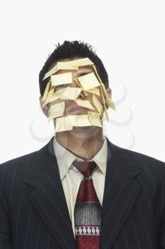 Businessman's face wrapped with adhesive notes