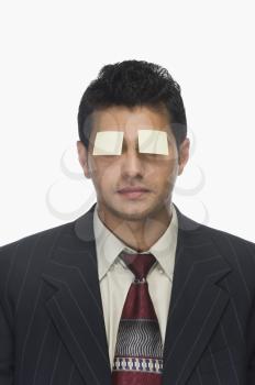 Adhesive notes on a businessman's eyes