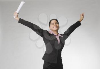 Businesswoman smiling with her arms raised
