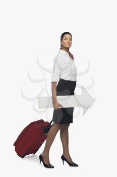 Air hostess carrying luggage with an arrow sign