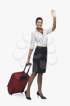 Air hostess carrying her luggage and waving