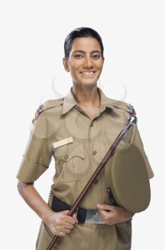 Portrait of a female police officer holding a stick and smiling