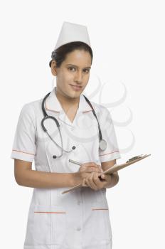 Female nurse holding a clipboard and smiling