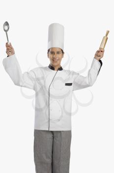 Female chef holding a rolling pin and a ladle