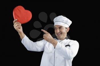 Chef pointing towards a heart shape gift