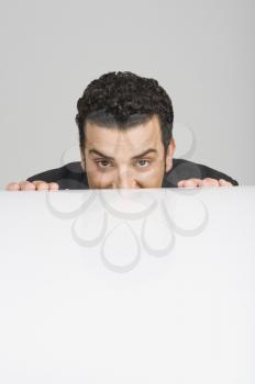 Businessman peeking over a desk