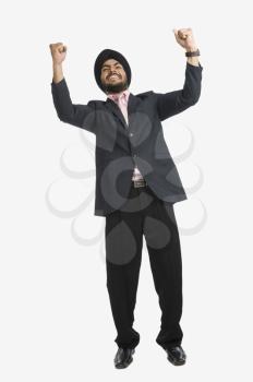 Businessman smiling with his arms raised
