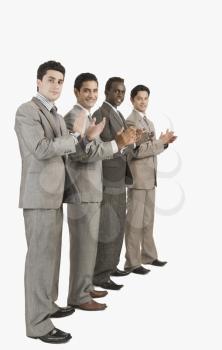 Portrait of four businessmen applauding