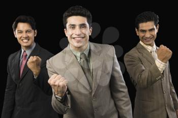 Portrait of three businessmen clenching fists