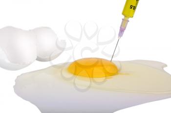 Syringe injecting yellow liquid in egg yolk