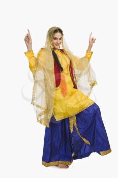 Woman in traditional yellow Punjabi dress doing bhangra