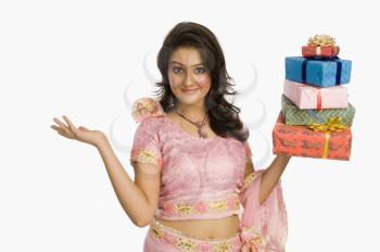 Portrait of a beautiful woman in traditional dress holding gifts and smiling