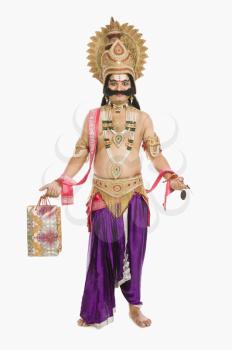 Stage artist dressed-up as Ravana holding a shopping bag