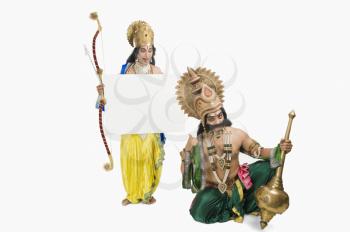 Two stage artists dressed-up as Rama and Ravana and holding a blank placard