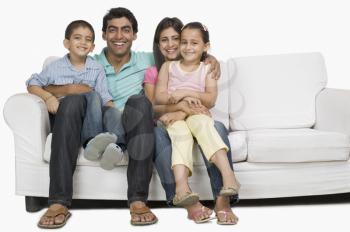 Portrait of a family sitting on a couch and smiling