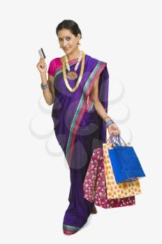 Portrait of a woman carrying shopping bags and a credit card