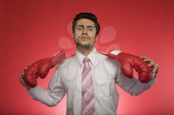 Portrait of a businessman holding boxing gloves