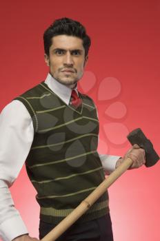 Portrait of a businessman holding a sledgehammer