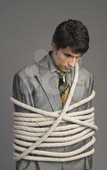 Close-up of a businessman tied up with ropes