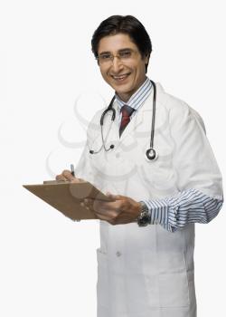 Portrait of a doctor writing on a clipboard and smiling