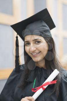 Woman in graduation gown holding a diploma