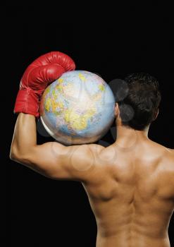 Male boxer holding a globe on his shoulder