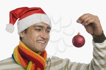 Man holding a Christmas ornament and smiling