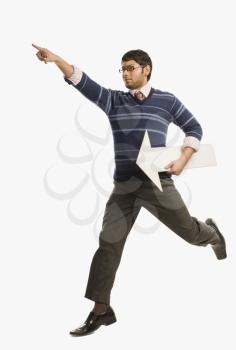 Businessman pointing forward and running with an arrow sign