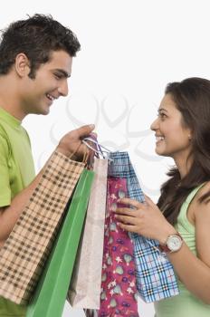 Couple carrying shopping bags and smiling