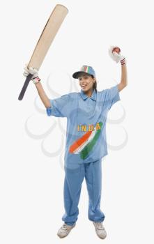 Female cricketer raising bat in celebration