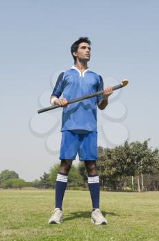 Man holding a hockey stick in a field