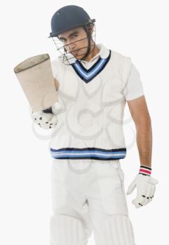 Portrait of a cricket batsman showing his bat