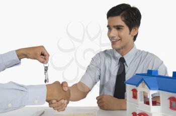 Real estate agent offering keys to a customer