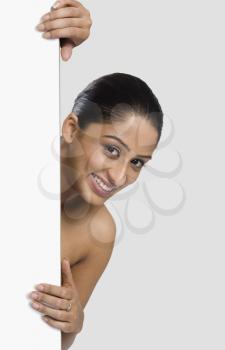 Woman peeking from behind a door