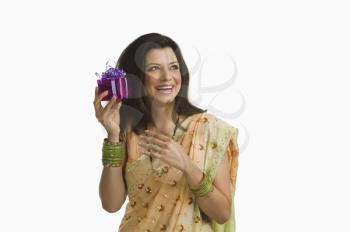 Woman holding Diwali gift and smiling